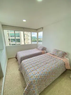 a bedroom with two beds and a large window at Apartamento frente al mar en Cartagena in Cartagena de Indias