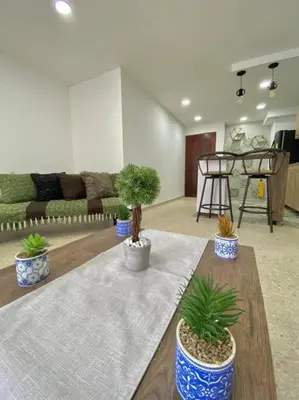 a living room with three potted plants on a table at Apartamento frente al mar en Cartagena in Cartagena de Indias