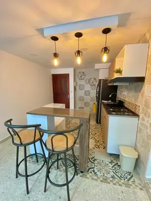 a kitchen with two chairs and a counter with a stove at Apartamento frente al mar en Cartagena in Cartagena de Indias