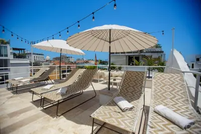 a patio with chairs and umbrellas on a roof at Sol de Alba Hotel Boutique in Cartagena de Indias