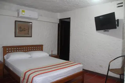 a bedroom with a bed and a flat screen tv at Villa Margarita in Puerto Colombia
