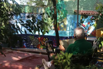 a man sitting in a chair in front of a painting at Villa Margarita in Puerto Colombia