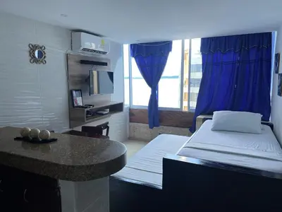 a room with a bed and a table and a window at Alojamientos Cartagena Edificio Atlantis y Conquistador in Cartagena de Indias