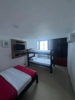 a room with a bed and a table and a microwave at Alojamientos Cartagena Edificio Atlantis y Conquistador in Cartagena de Indias