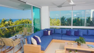 a living room with a blue couch and a large window at Magico Apartamento Frente al Mar 4 Habitaciones PAZ345 in Coveñitas
