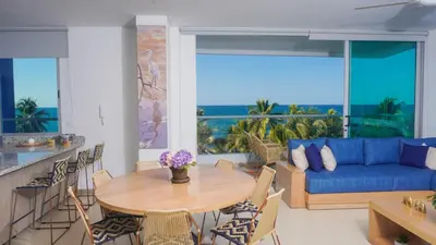 a living room with a table and a blue couch at Magico Apartamento Frente al Mar 4 Habitaciones PAZ345 in Coveñitas