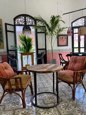 a room with chairs and a wooden table and chairs at Al Alma Apart-Suites in Cartagena de Indias