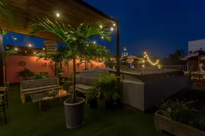 a patio with palm trees and lights at night at Al Alma Apart-Suites in Cartagena de Indias