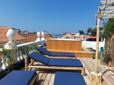 a deck with blue lounge chairs on a roof at Al Alma Apart-Suites in Cartagena de Indias