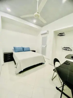 a white bedroom with a bed and a desk at Hostal La Princesa in Cartagena de Indias