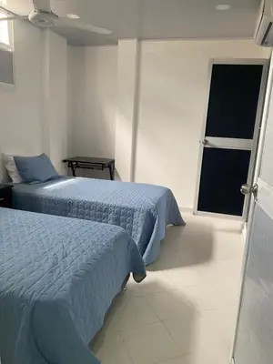 a bedroom with two beds and a window at Hostal La Princesa in Cartagena de Indias