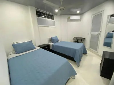 a room with two beds and a tv in it at Hostal La Princesa in Cartagena de Indias