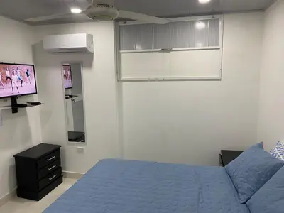 a bedroom with a bed and a flat screen tv at Hostal La Princesa in Cartagena de Indias