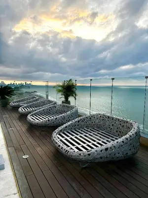 a row of white chairs sitting on a wooden deck at Hermoso apartamento con vista al mar y salida directa a la playa in Cartagena de Indias