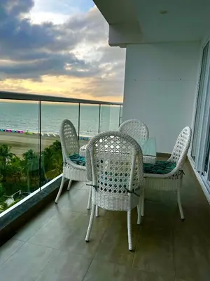 a balcony with wicker chairs and a view of the ocean at Hermoso apartamento con vista al mar y salida directa a la playa in Cartagena de Indias