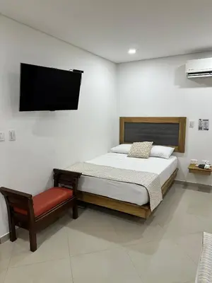 a bedroom with a bed and a tv on the wall at Hotel El Faro - Desayunos incluidos - Manga, Cartagena in Cartagena de Indias