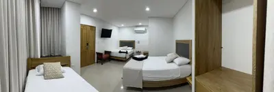 a hotel room with two beds and a bathroom at Hotel El Faro - Desayunos incluidos - Manga, Cartagena in Cartagena de Indias