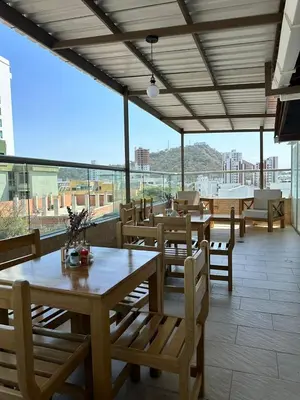a restaurant with wooden tables and chairs and a large window at Hotel El Faro - Desayunos incluidos - Manga, Cartagena in Cartagena de Indias