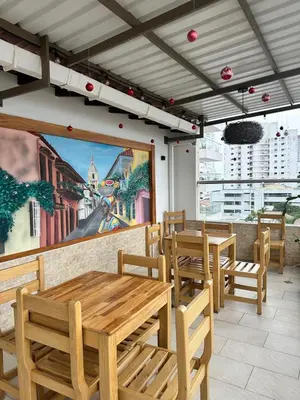 a restaurant with wooden tables and chairs and a mural at Hotel El Faro - Desayunos incluidos - Manga, Cartagena in Cartagena de Indias