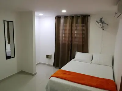 a small bedroom with a bed and a window at Hotel Don Jose in Ciénaga