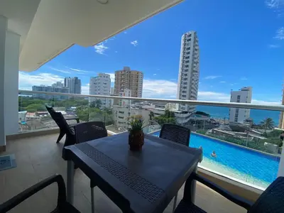 a balcony with a table and chairs and a pool at Cartagena 3 habitaciones 9 personas cerca a la playa Wifi y Parqueadero in Cartagena de Indias