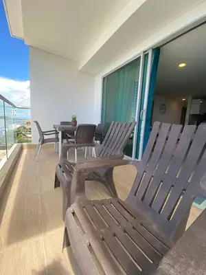 two wooden chairs and a table on a balcony at Cartagena 3 habitaciones 9 personas cerca a la playa Wifi y Parqueadero in Cartagena de Indias