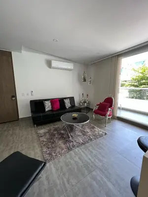 a living room with a black couch and a table at Cerca al Hotel Americas Ctgna Spiaggia Morros Piscina playa in Cartagena de Indias