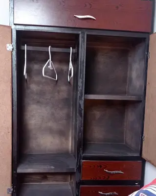 a wooden cabinet with two hangers in it at Hostal-Mirador La Popa in Cartagena de Indias