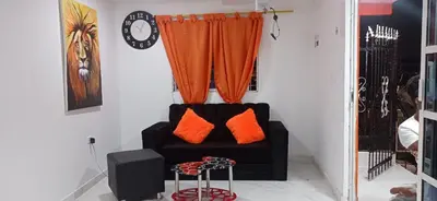 a black couch with orange pillows in a room at Hostal-Mirador La Popa in Cartagena de Indias