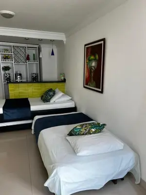 a bedroom with two beds and a painting on the wall at Apartamento in Cartagena de Indias