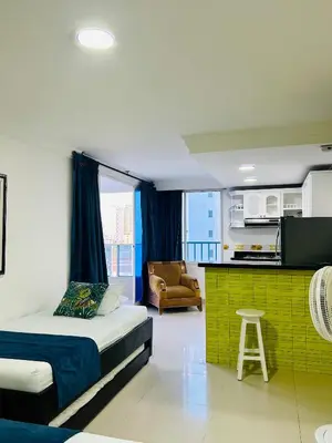 a bedroom with a bed and a kitchen with a table at Apartamento in Cartagena de Indias