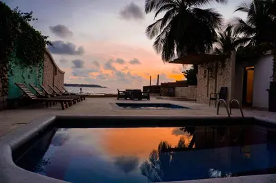 a swimming pool with a sunset in the background at Hotel Caribbean Cartagena in Cartagena de Indias