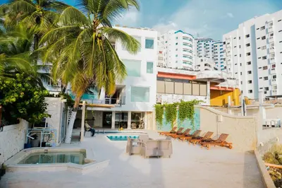 a resort with a pool and palm trees and buildings at Hotel Caribbean Cartagena in Cartagena de Indias