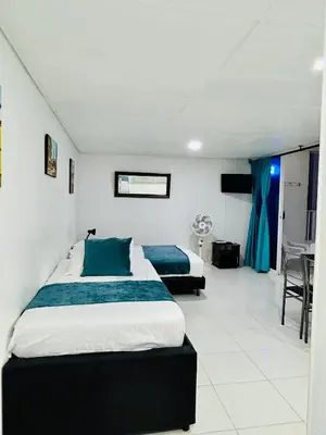 a bedroom with two beds with blue pillows at Apartaestudio in Cartagena de Indias