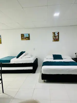 two beds in a white room with two beds at Apartaestudio in Cartagena de Indias