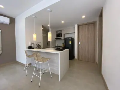 a kitchen with two chairs and a counter in a room at Manzanillo Bay Aparments by Wynwood House in Cartagena de Indias