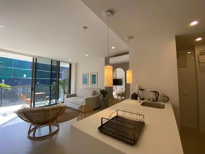 a living room with a kitchen and a living room with a couch at Manzanillo Bay Aparments by Wynwood House in Cartagena de Indias