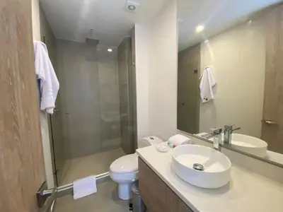 a bathroom with a sink and a toilet and a mirror at Manzanillo Bay Aparments by Wynwood House in Cartagena de Indias