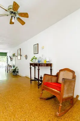 a living room with a chair and a ceiling fan at Casa Verde El Golf in Barranquilla