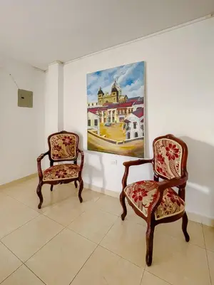 two chairs in a room with a painting on the wall at 3CB-2 APARTAMENTO DE 3 ALCOBAS EN EL CENTRO HISTORICO CON AIRE ACONDICIONADO Y WIFI in Cartagena de Indias