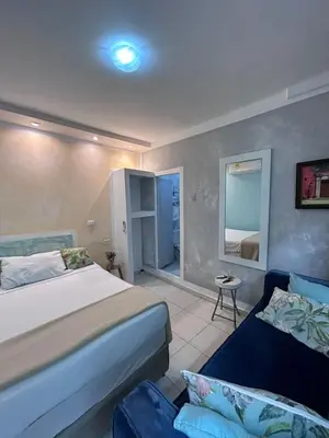 a bedroom with a bed and a couch in it at 3CB-1 APARTAMENTO DE 3 ALCOBAS EN EL CENTRO HISTORICO CON AIRE ACONDICIONADO Y WIFI in Cartagena de Indias