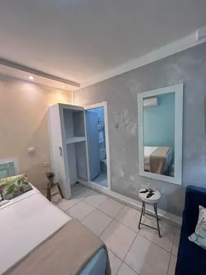 a bedroom with a bed and a mirror and a chair at 3CB-1 APARTAMENTO DE 3 ALCOBAS EN EL CENTRO HISTORICO CON AIRE ACONDICIONADO Y WIFI in Cartagena de Indias