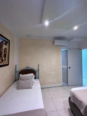 a bedroom with two beds in a room with a window at 3CB-1 APARTAMENTO DE 3 ALCOBAS EN EL CENTRO HISTORICO CON AIRE ACONDICIONADO Y WIFI in Cartagena de Indias