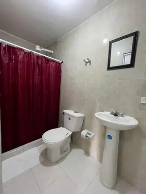 a bathroom with a toilet and a red shower curtain at 2CB-3 APARTAMENTO DE 2 ALCOBAS EN EL CENTRO HISTORICO CON AIRE ACONDICIONADO Y WIFI in Cartagena de Indias