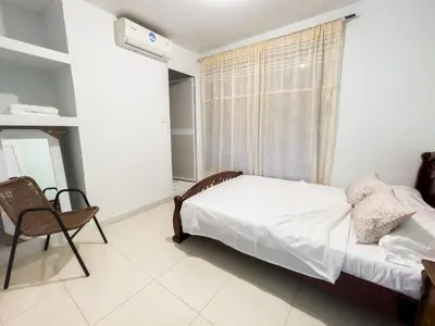 a bedroom with a bed and a chair and a window at 2CB-3 APARTAMENTO DE 2 ALCOBAS EN EL CENTRO HISTORICO CON AIRE ACONDICIONADO Y WIFI in Cartagena de Indias