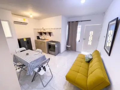 a living room with a yellow couch and a table at 2CB-4 APARTAMENTO DE 2 ALCOBAS EN EL CENTRO HISTORICO CON AIRE ACONDICIONADO Y WIFI in Cartagena de Indias