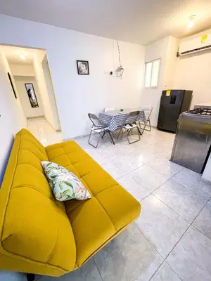 a yellow couch in a living room with a table at 2CB-4 APARTAMENTO DE 2 ALCOBAS EN EL CENTRO HISTORICO CON AIRE ACONDICIONADO Y WIFI in Cartagena de Indias