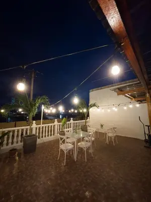 a patio with a table and chairs at night at 2CB-4 APARTAMENTO DE 2 ALCOBAS EN EL CENTRO HISTORICO CON AIRE ACONDICIONADO Y WIFI in Cartagena de Indias