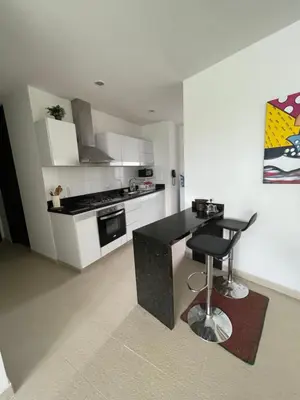 a kitchen with a black counter and a stool at Acogedor apartamento con vista al mar en coveñas in Coveñas