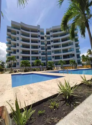 a hotel with a swimming pool in front of a building at Acogedor apartamento con vista al mar en coveñas in Coveñas